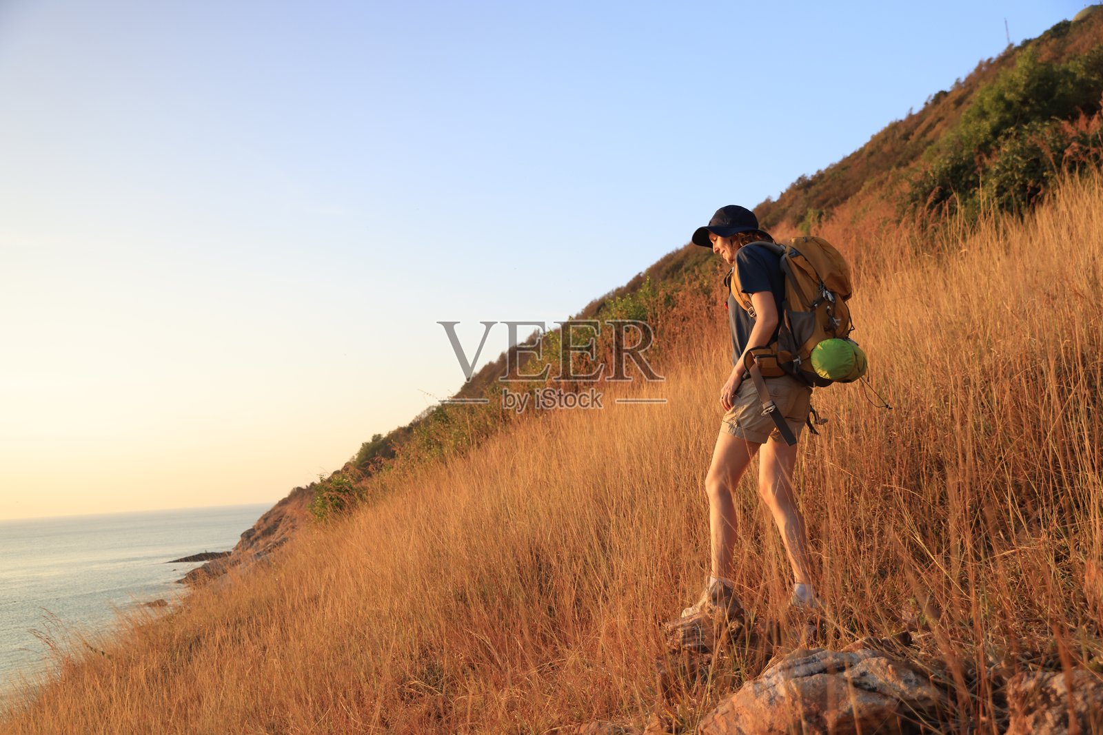 女性背包客在棕色山脉上冒险徒步旅行照片摄影图片