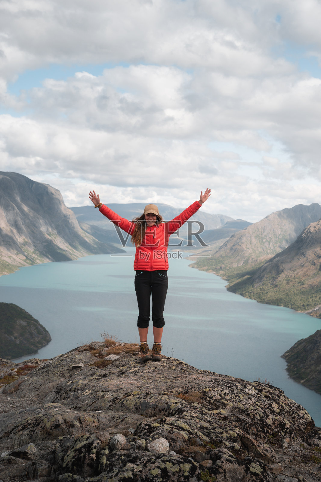 在挪威峡湾背景下，女性在山顶庆祝，适合徒步探险。照片摄影图片