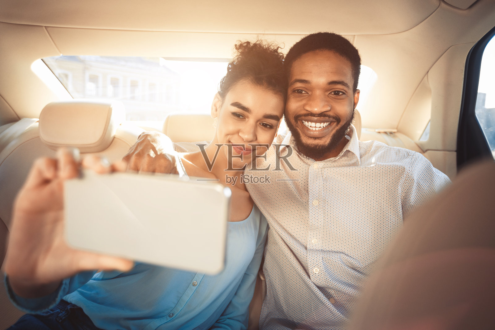 情侣在阳光明媚的日子里在车后座愉快地自拍照片摄影图片