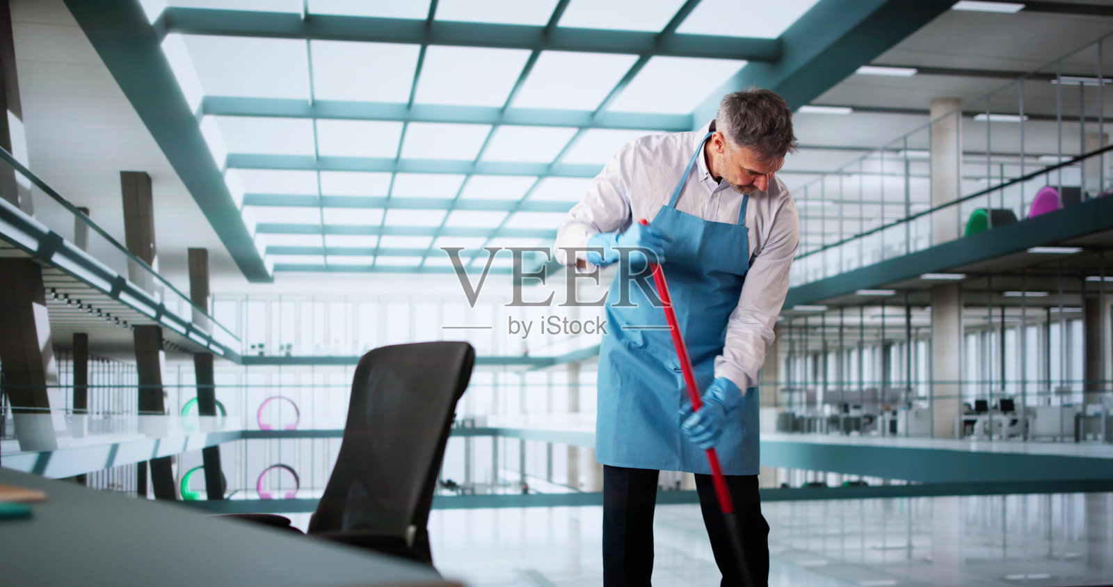 男清洁工用拖把清洁地板照片摄影图片