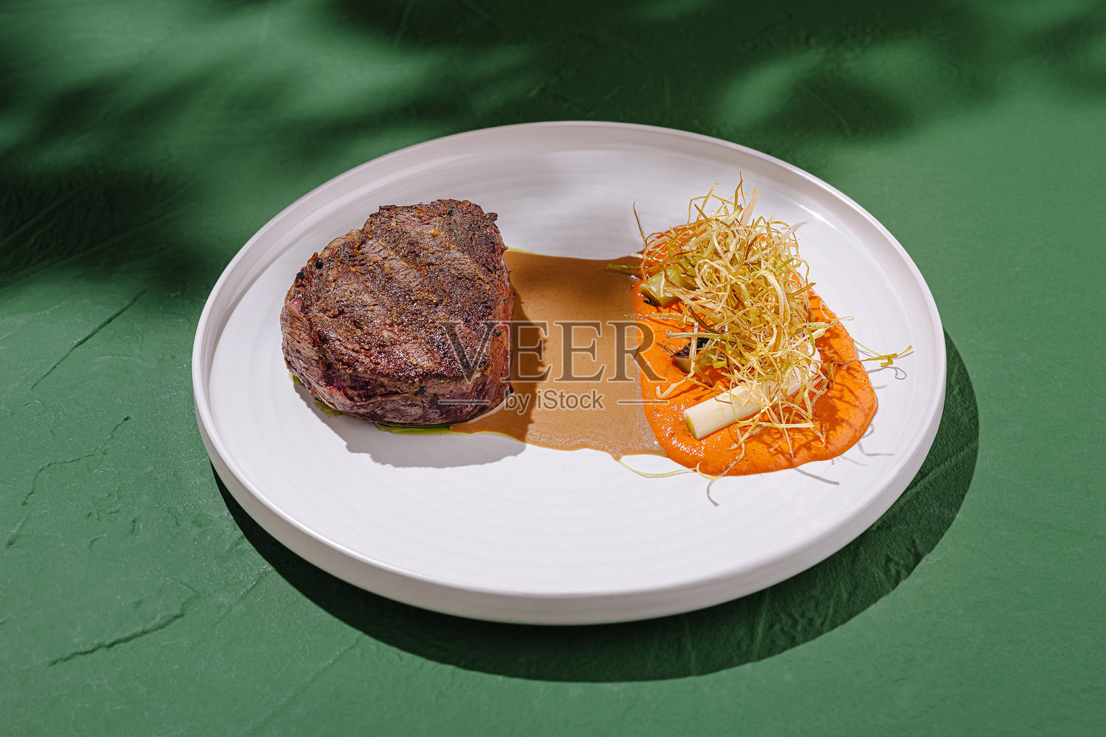 多汁的烤牛排配上鲜艳的酱 puree 和新鲜的装饰，在户外烹饪活动中呈现照片摄影图片