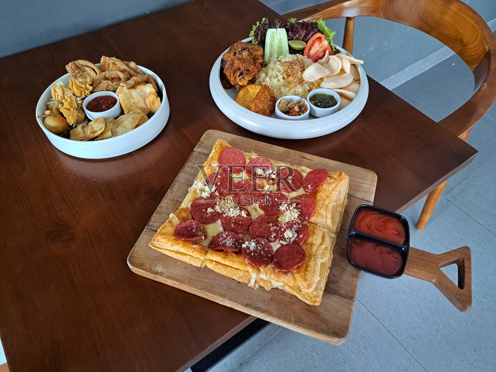 意大利香肠比萨。巴厘岛烤鸡饭或龙目岛烤鸡饭。小吃拼盘，包括鸡蛋卷、饺子、马尔塔巴克或脆皮炸蔬菜包、炸豆腐、脆皮蔬菜和曼谷辣酱。菜单。照片摄影图片