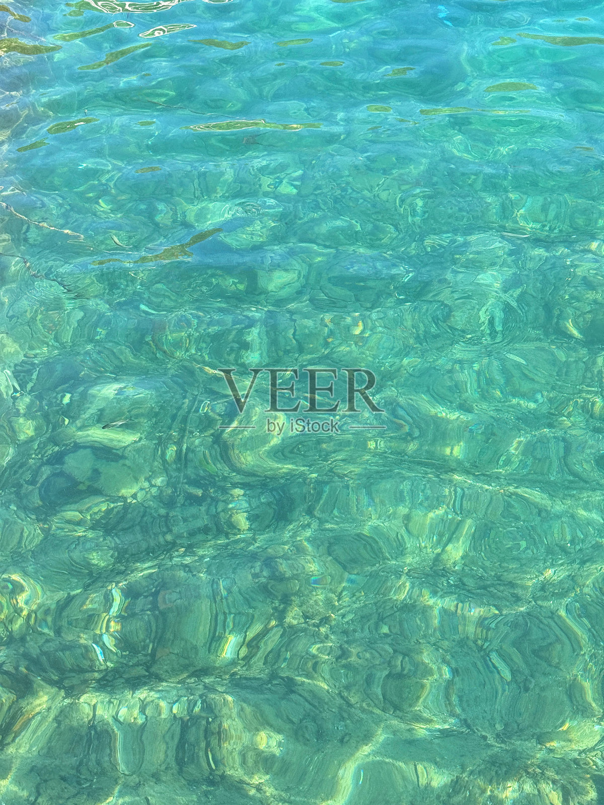 绿色透明的海水表面。照片摄影图片