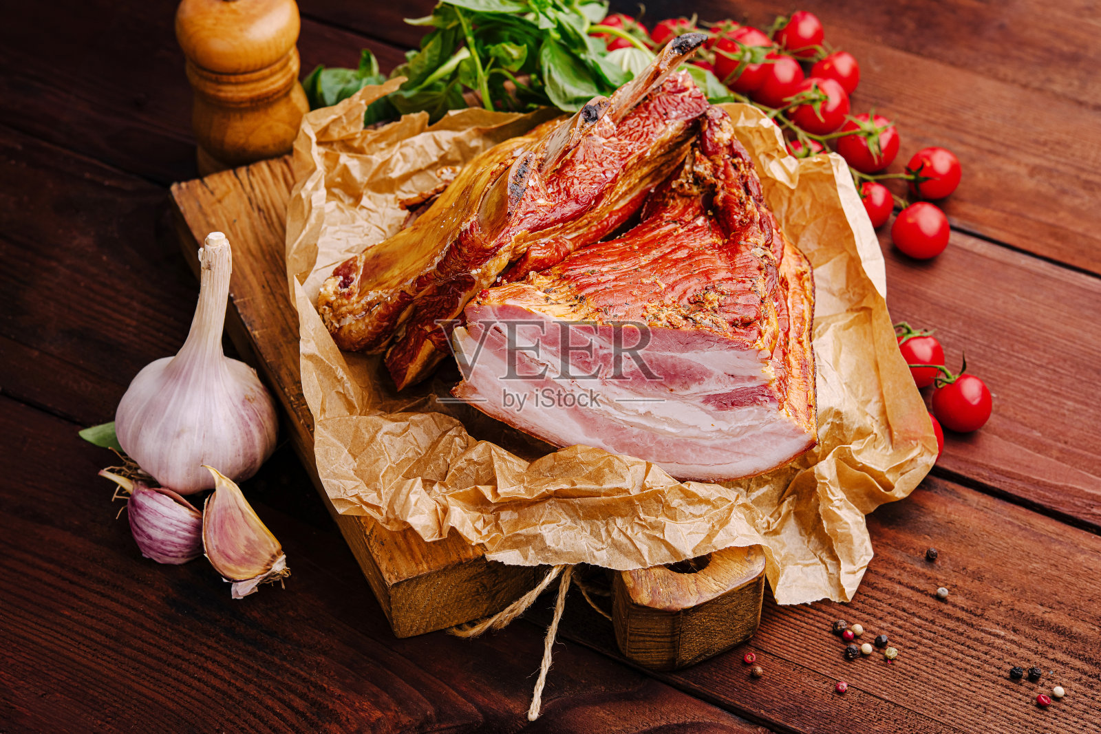 新鲜切片的肉与大蒜和樱桃番茄放在木桌上照片摄影图片