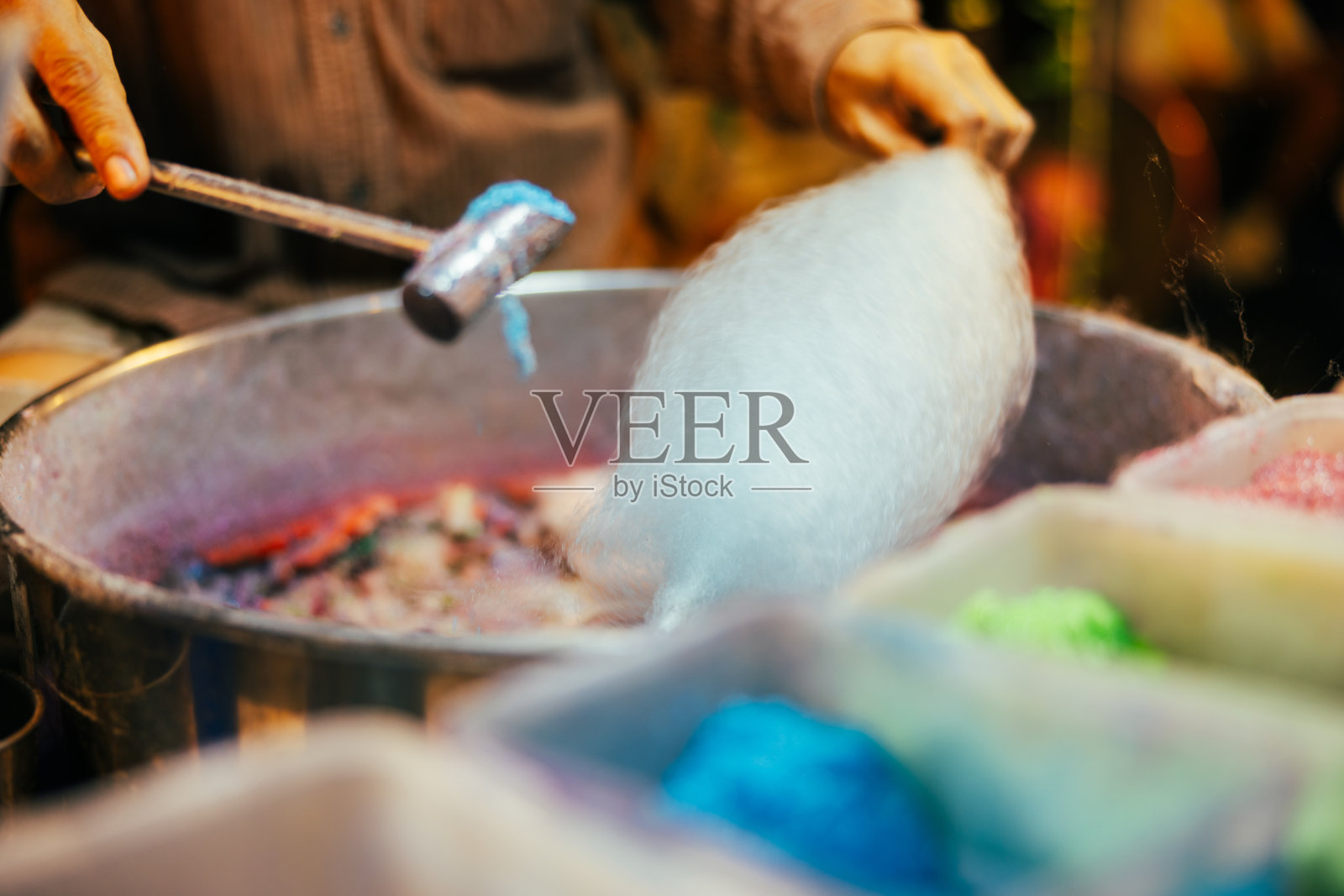 一名男子在街头美食市场制作棉花糖。照片摄影图片