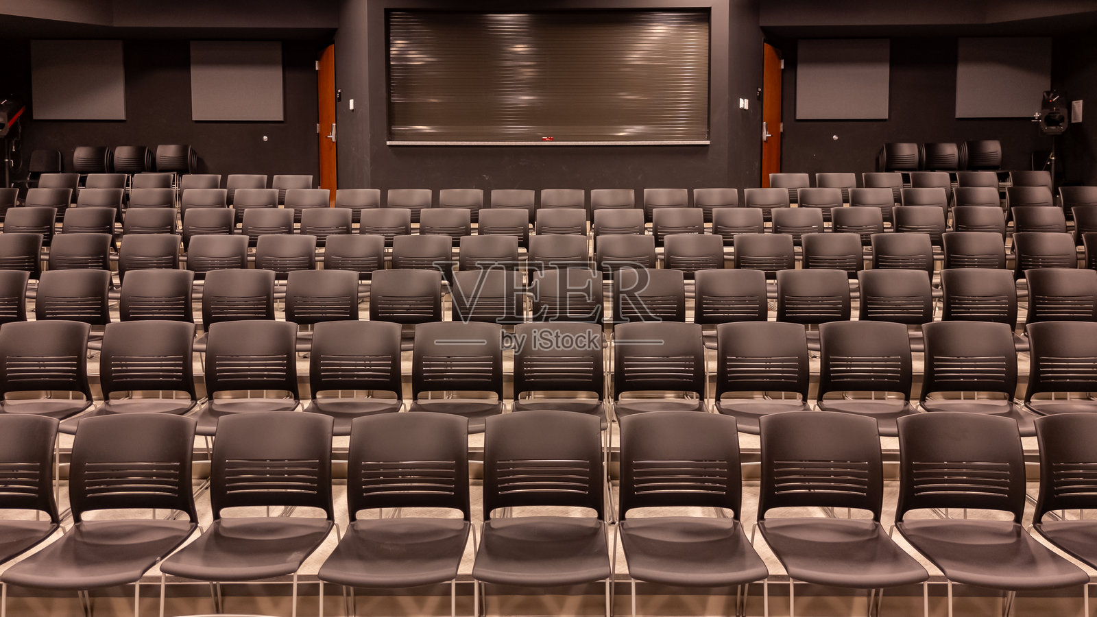 新学校剧院的照片，礼堂，大型教学空间，配有灰色座椅和椅子。照片摄影图片