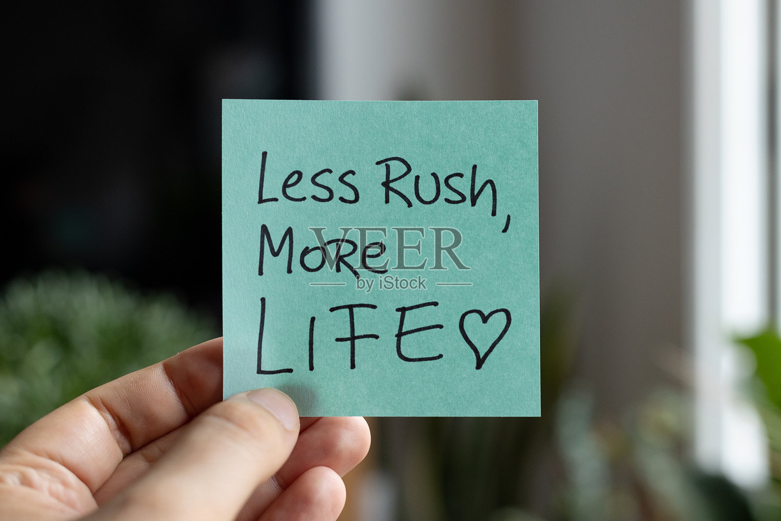 彩色纸上的便签纸，写着“少点匆忙，多点生活”照片摄影图片