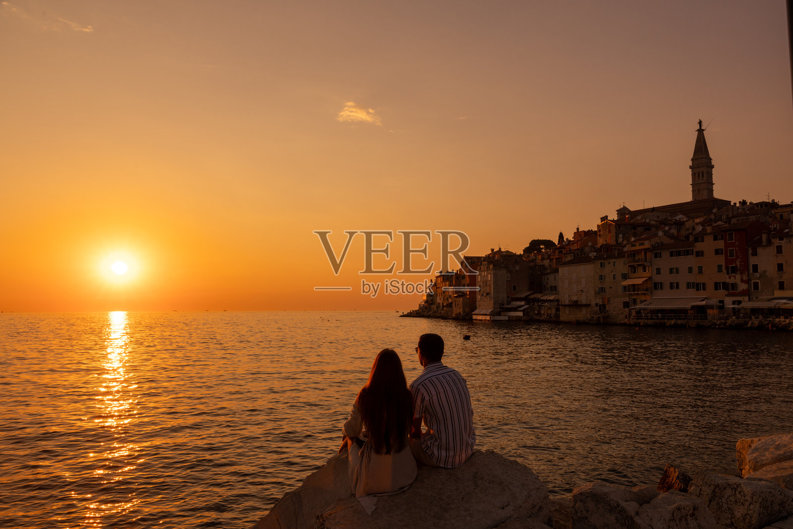 情侣在海滨小镇享受日落照片摄影图片