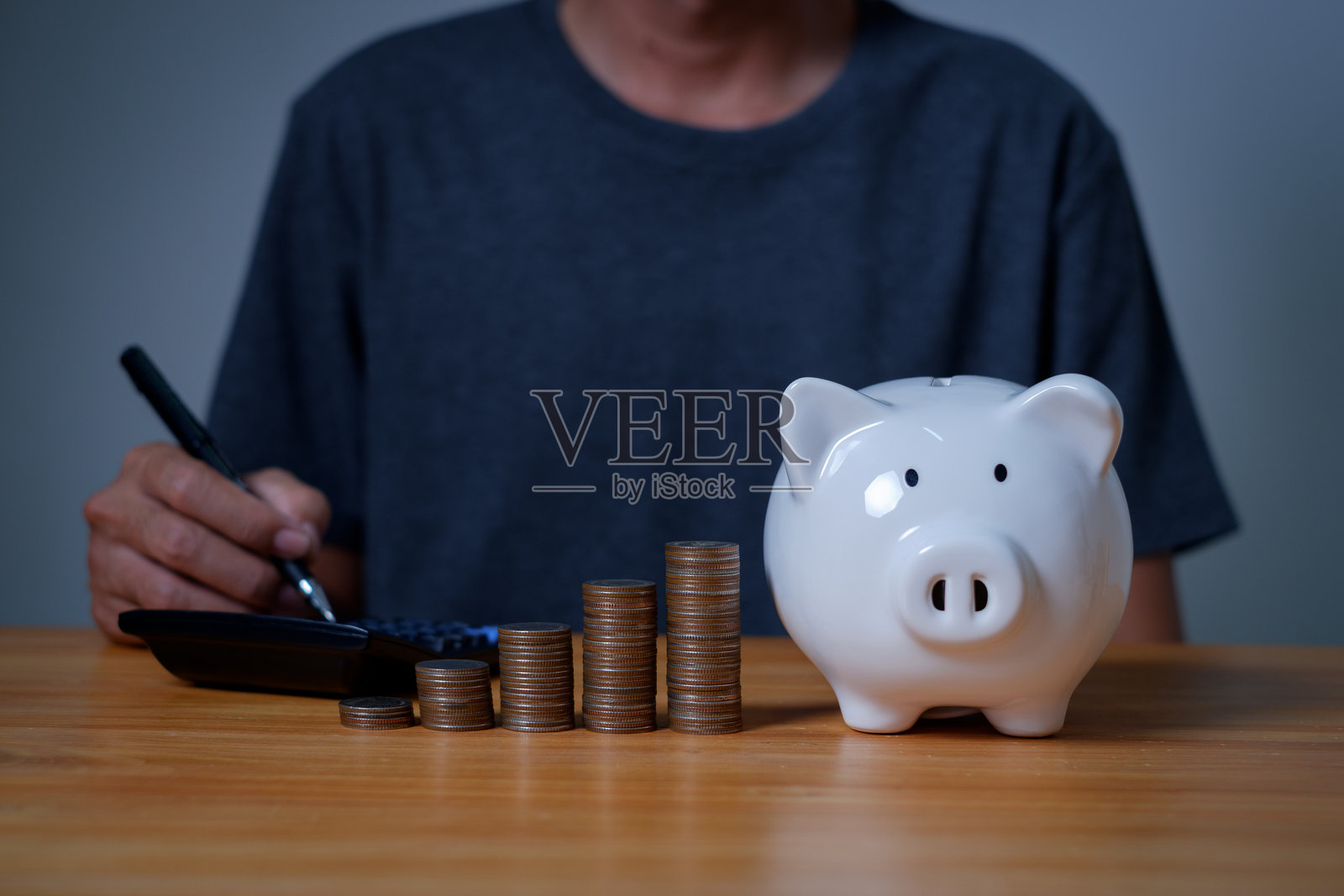 一个人的手放硬币的特写图像。储蓄理财概念、理财、投资、理财规划、企业投资理财会计概念。照片摄影图片