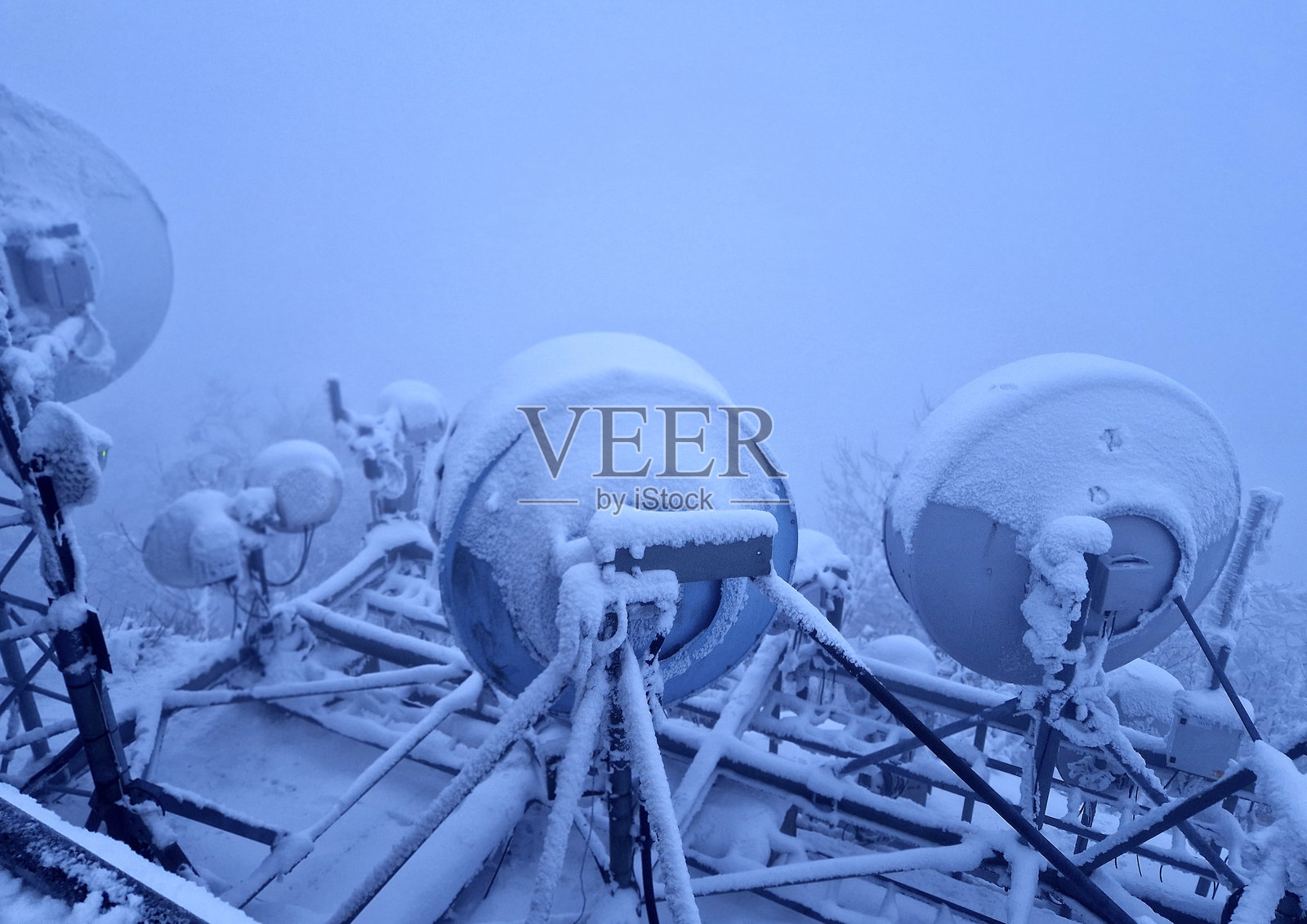 水库在积雪覆盖的屋顶上安装了发射机、放大器和GSM天线。磨砂和被冰覆盖可能会停止正常工作。照片摄影图片