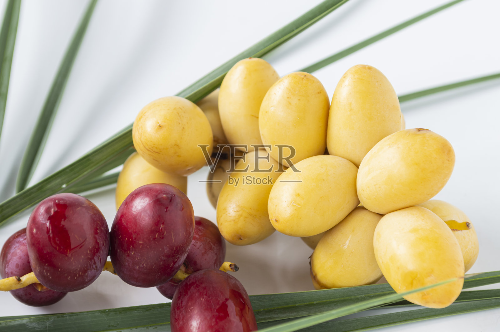 亮红色和黄色的枣椰树和叶子照片摄影图片