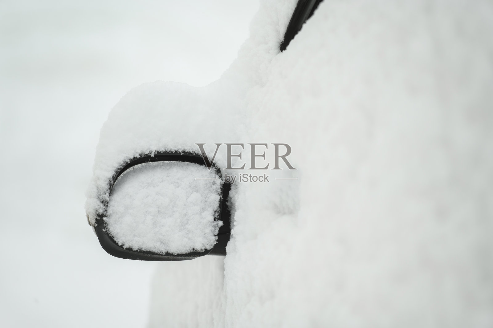 一场大雪过后，汽车被雪覆盖，特写。汽车雨刷起了。雪风暴。照片摄影图片