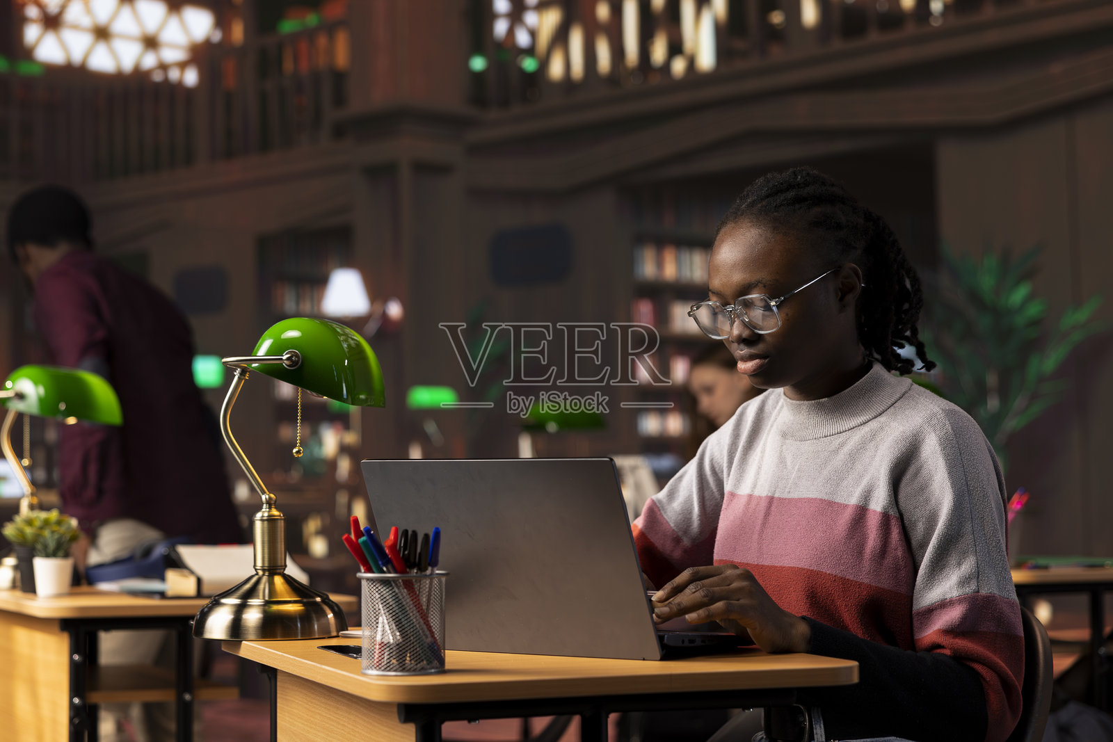 年轻的黑人学生专注于文学作业，收集资料照片摄影图片