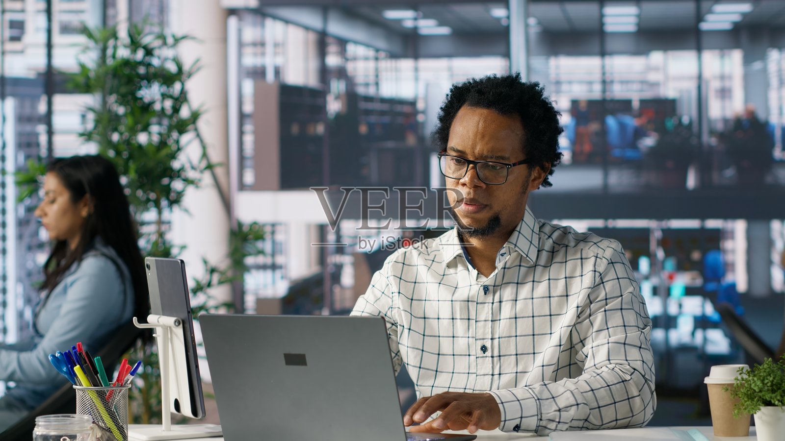 商务合伙人坐在笔记本电脑前，因过多的公司任务而感到压力。照片摄影图片