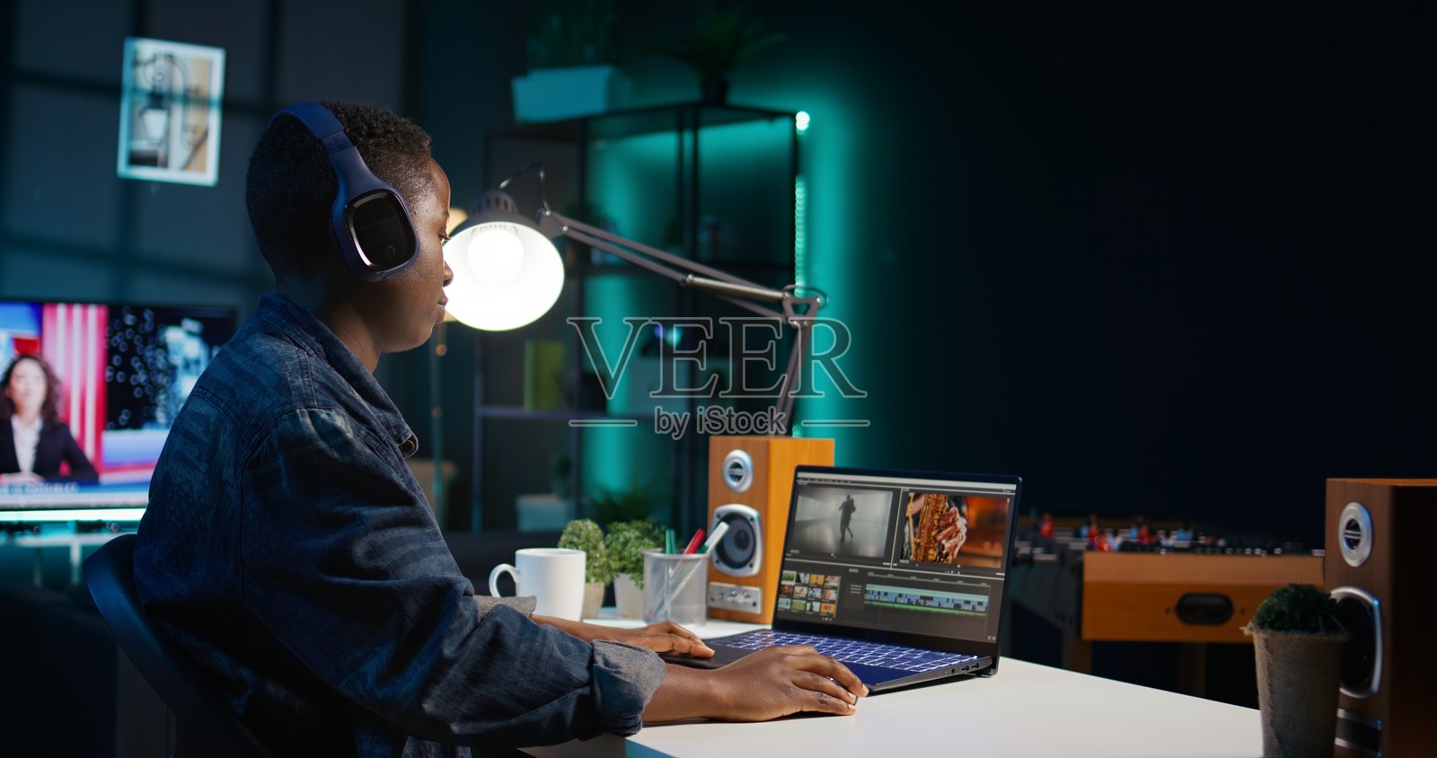 视频编辑在录制的镜头上添加音效，佩戴着耳机。照片摄影图片