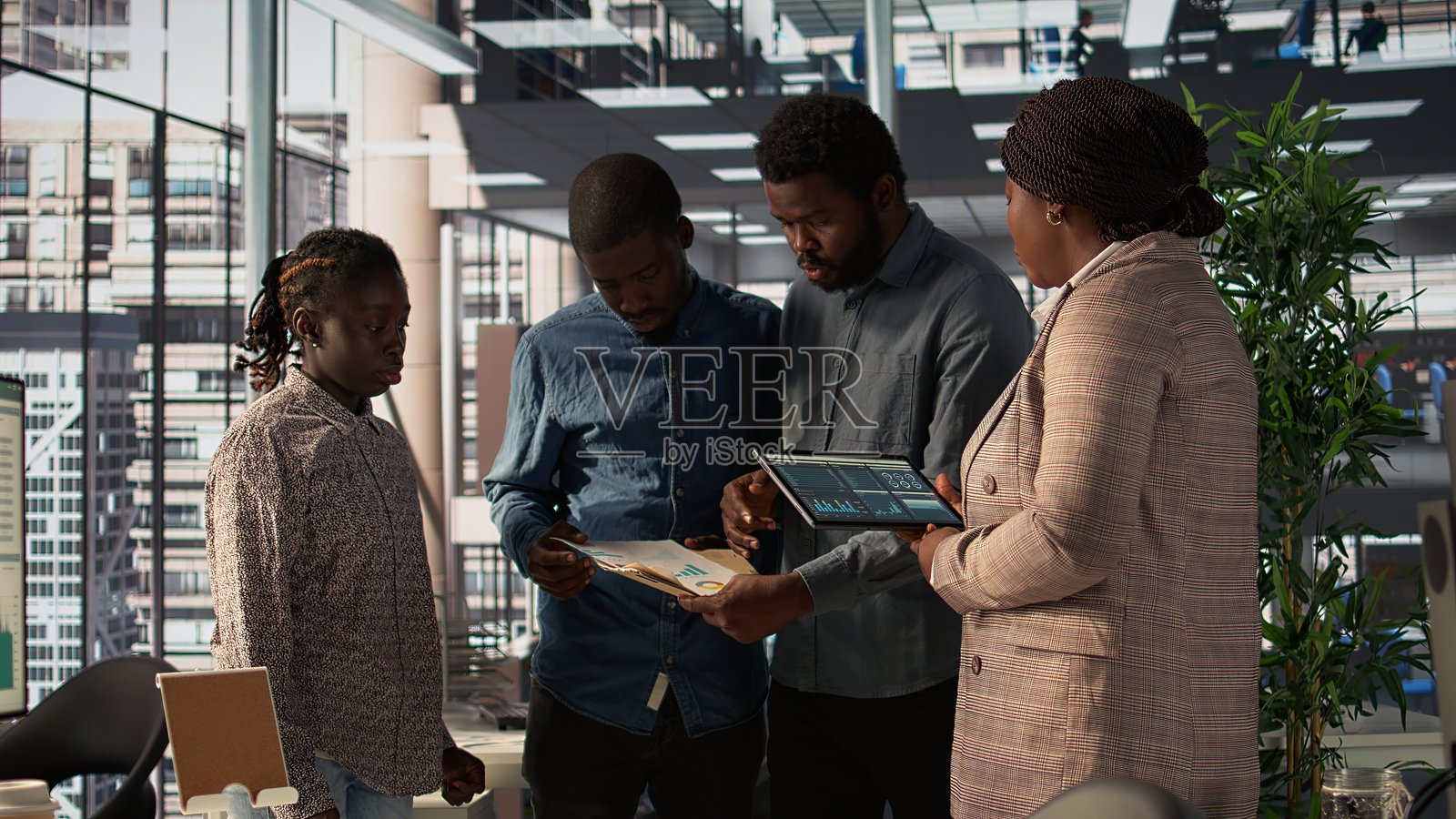 黑人女性领导在公司办公室与团队成员审查公司战略照片摄影图片