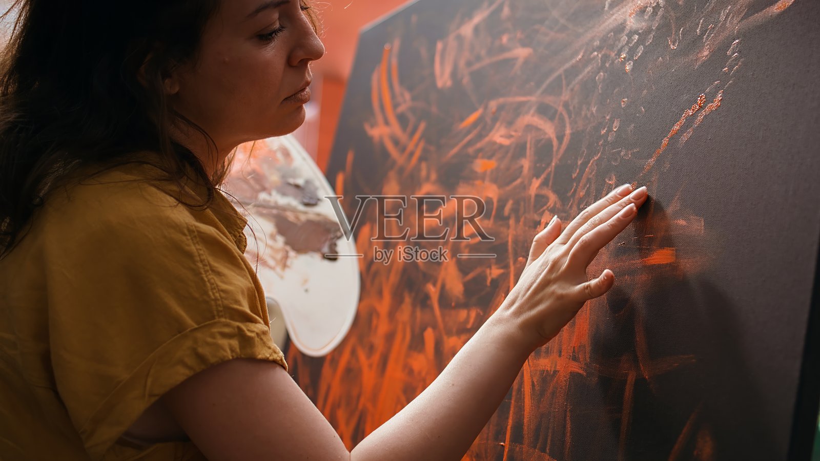 自信的艺术家站在画架前，用手指作画照片摄影图片