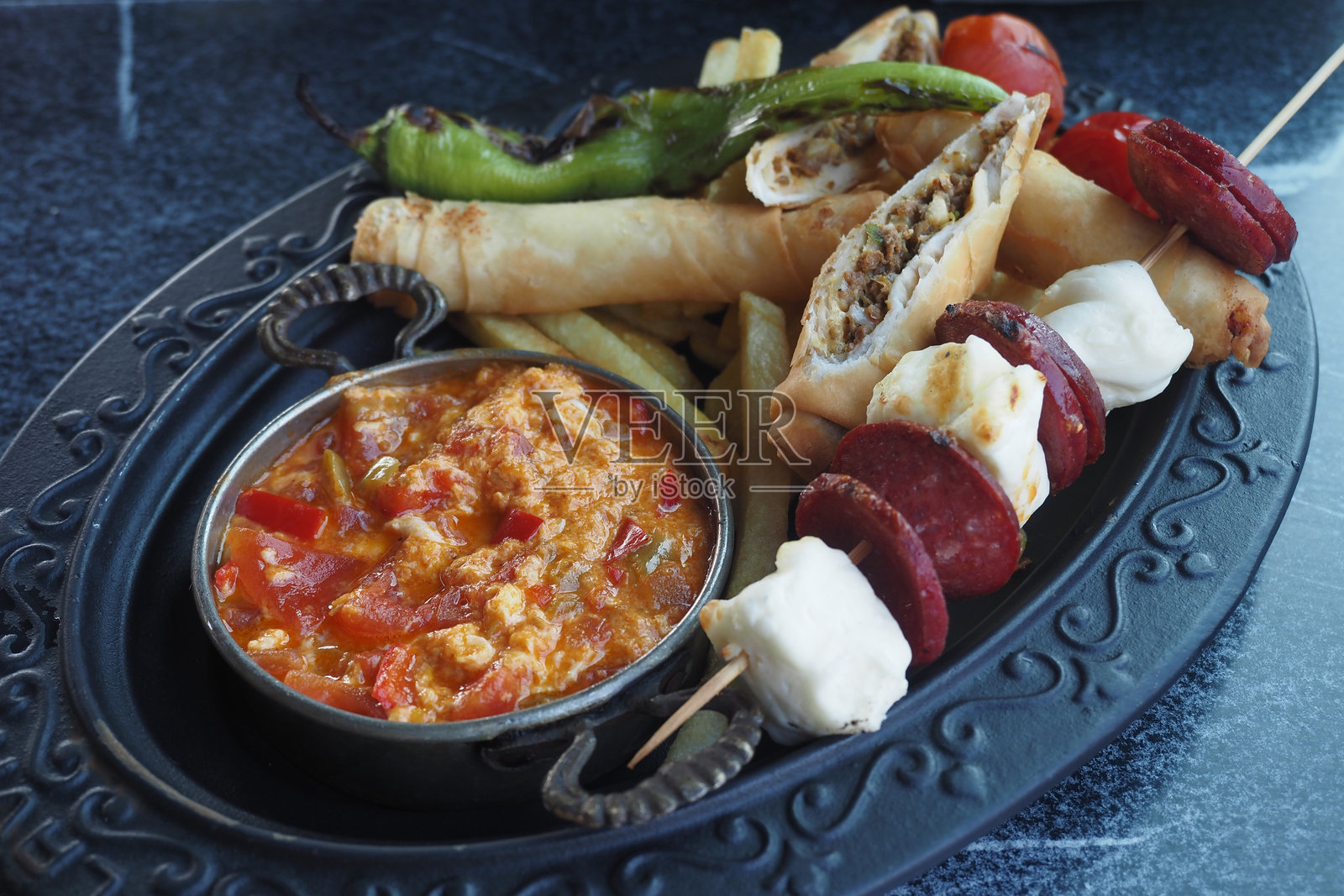 美味的拼盘，搭配卷状美食和香浓可口的蘸酱照片摄影图片