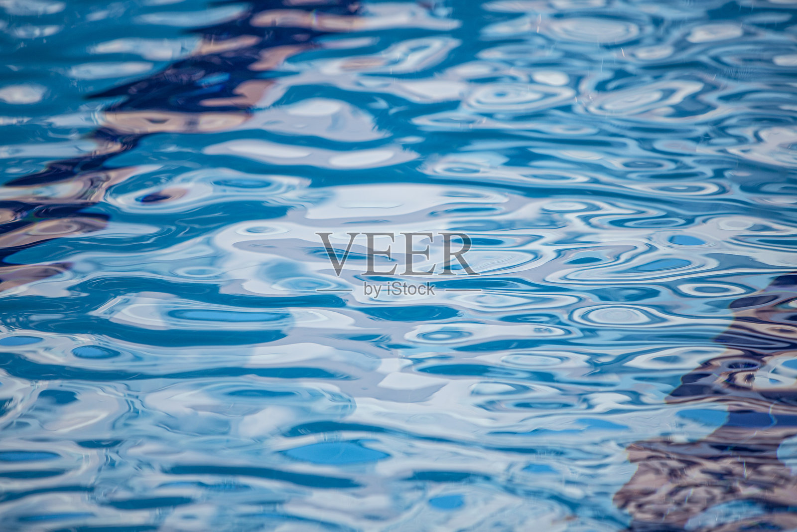 清澈的蓝色游泳池水面泛起轻柔的涟漪照片摄影图片