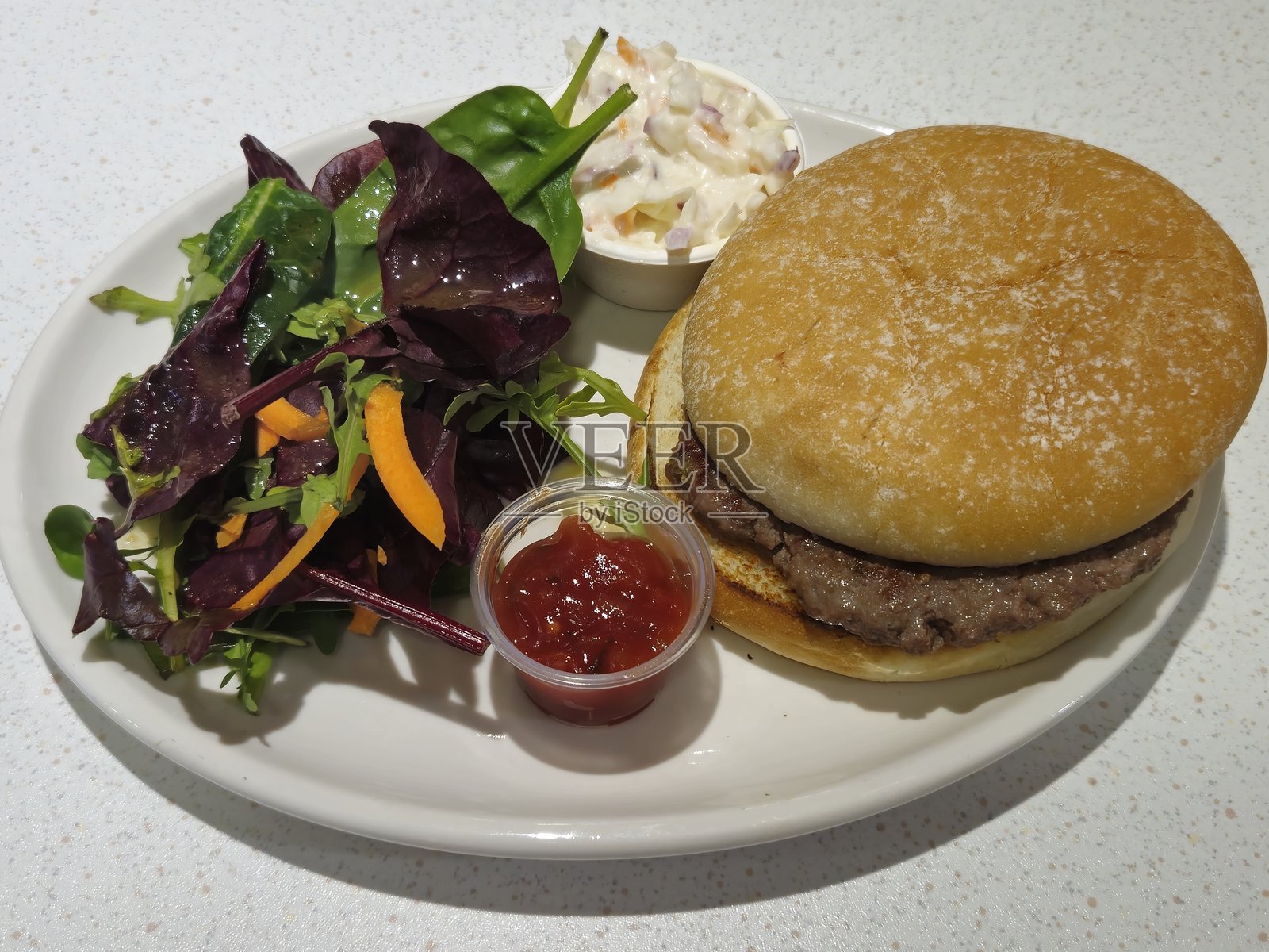 在苏格兰廷德伦享用的汉堡、叶子沙拉、卷心菜沙拉和番茄酱照片摄影图片