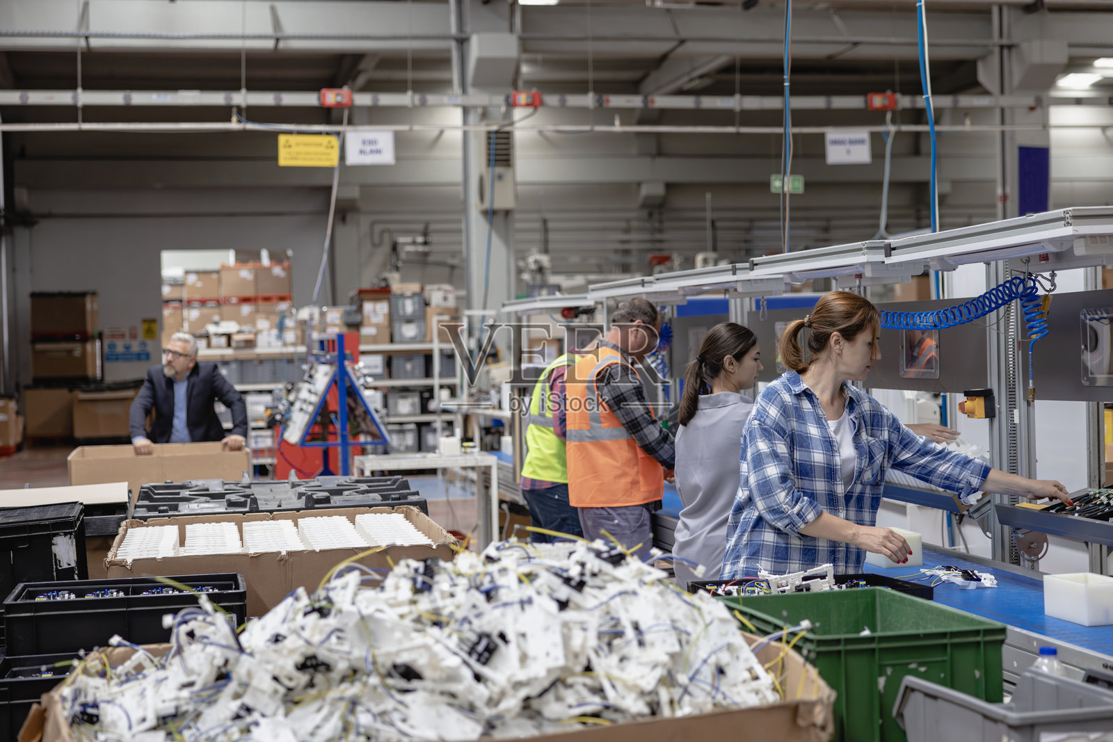 工人团队在工厂的生产线上使用螺丝工具进行工作照片摄影图片