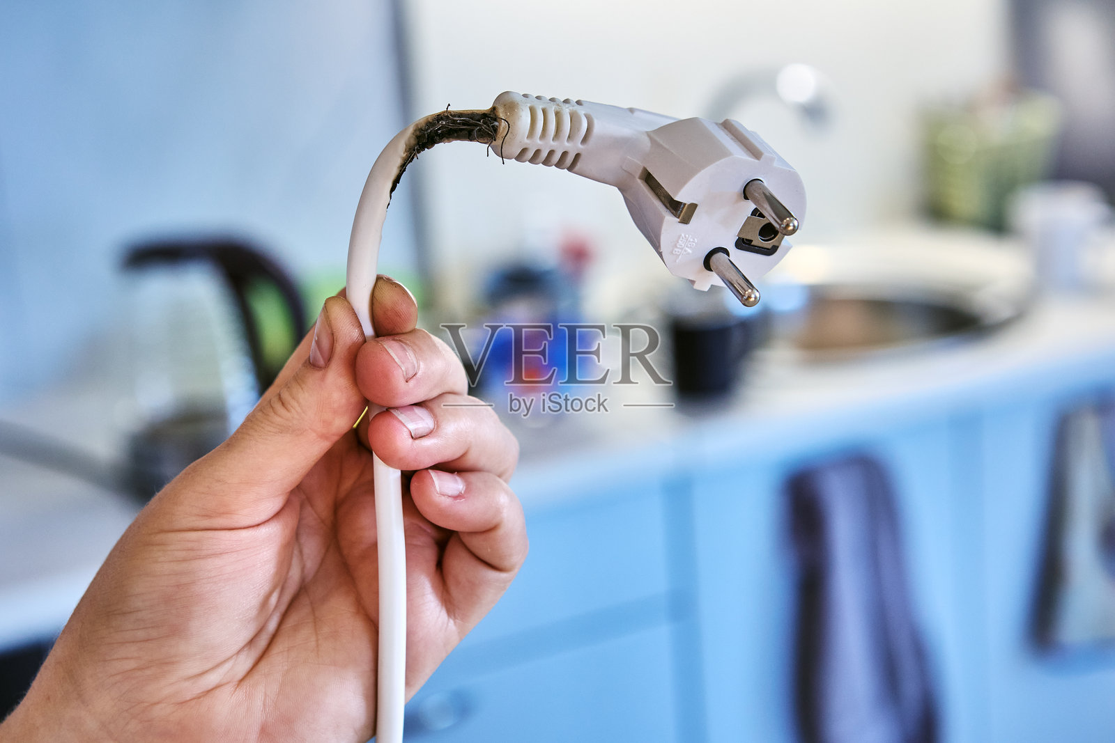 由于过载而熔化和烧焦的延长线，可能会引发火灾。照片摄影图片