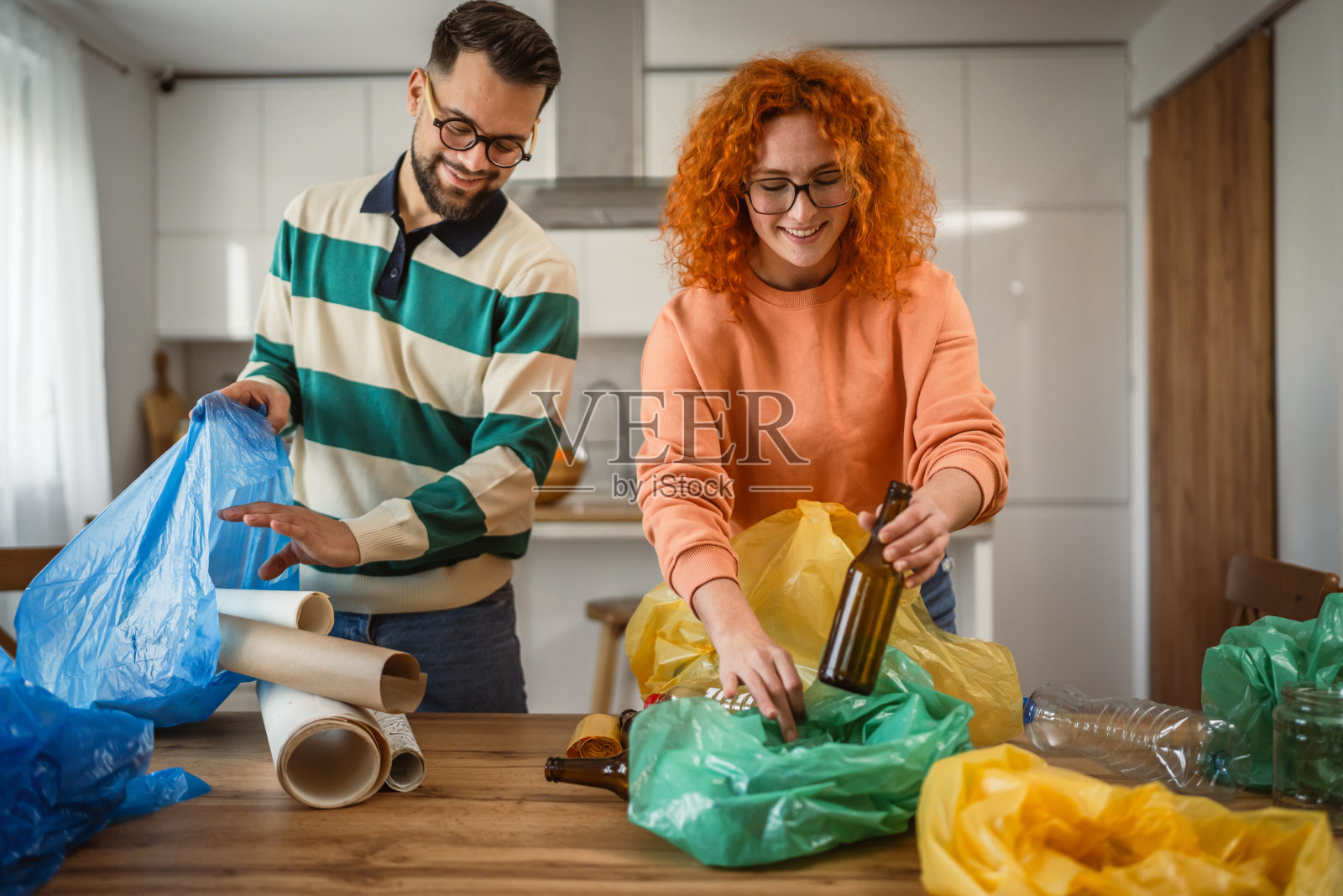 男女在家中回收分类废弃的塑料、纸张和玻璃。照片摄影图片