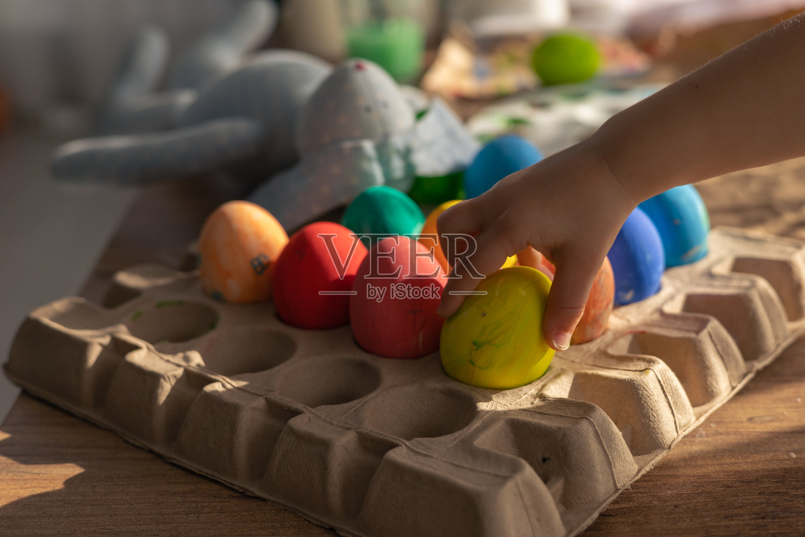 春季庆祝活动，五彩缤纷的复活节彩蛋和毛绒兔子在节日氛围中照片摄影图片
