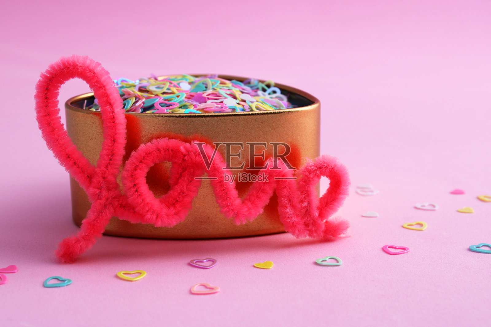 “爱”字旁边的金色心形容器照片摄影图片