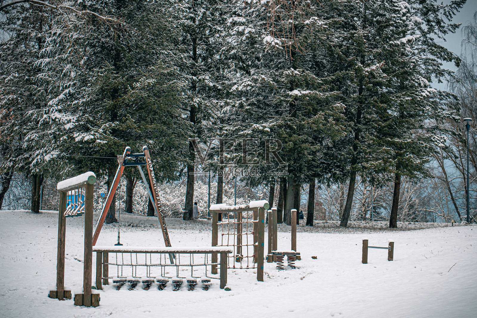 美丽的城市公共公园，冬天雪覆盖的树木、湖泊和长椅照片摄影图片