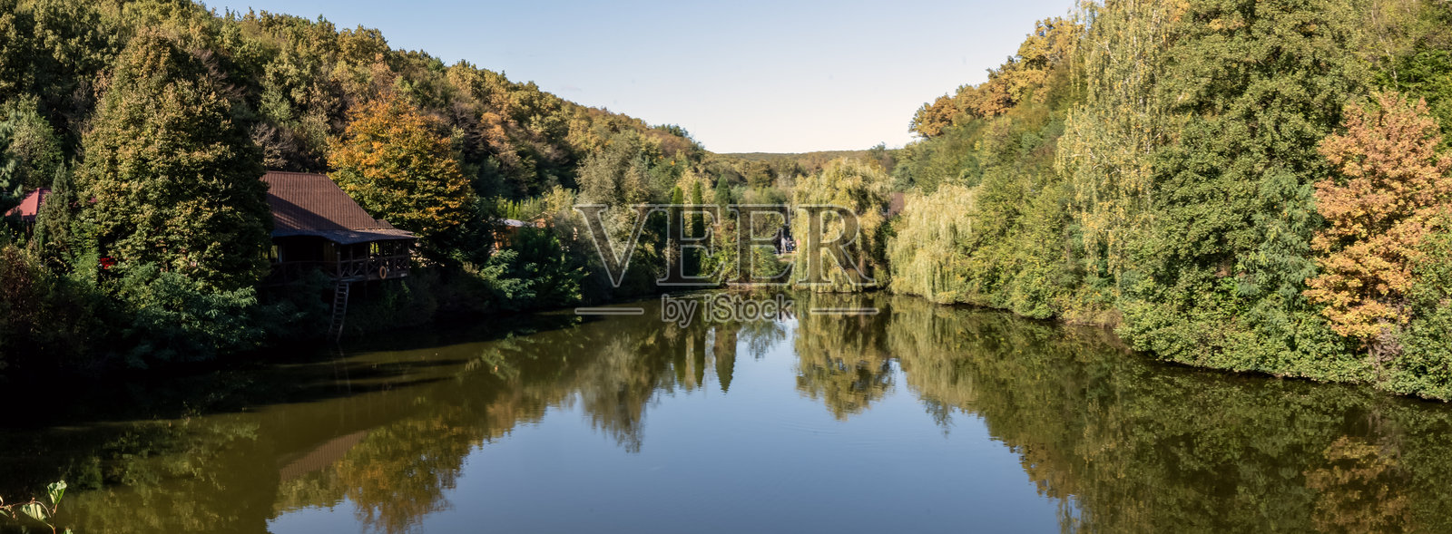 湖泊全景，四周环绕着秋季森林照片摄影图片