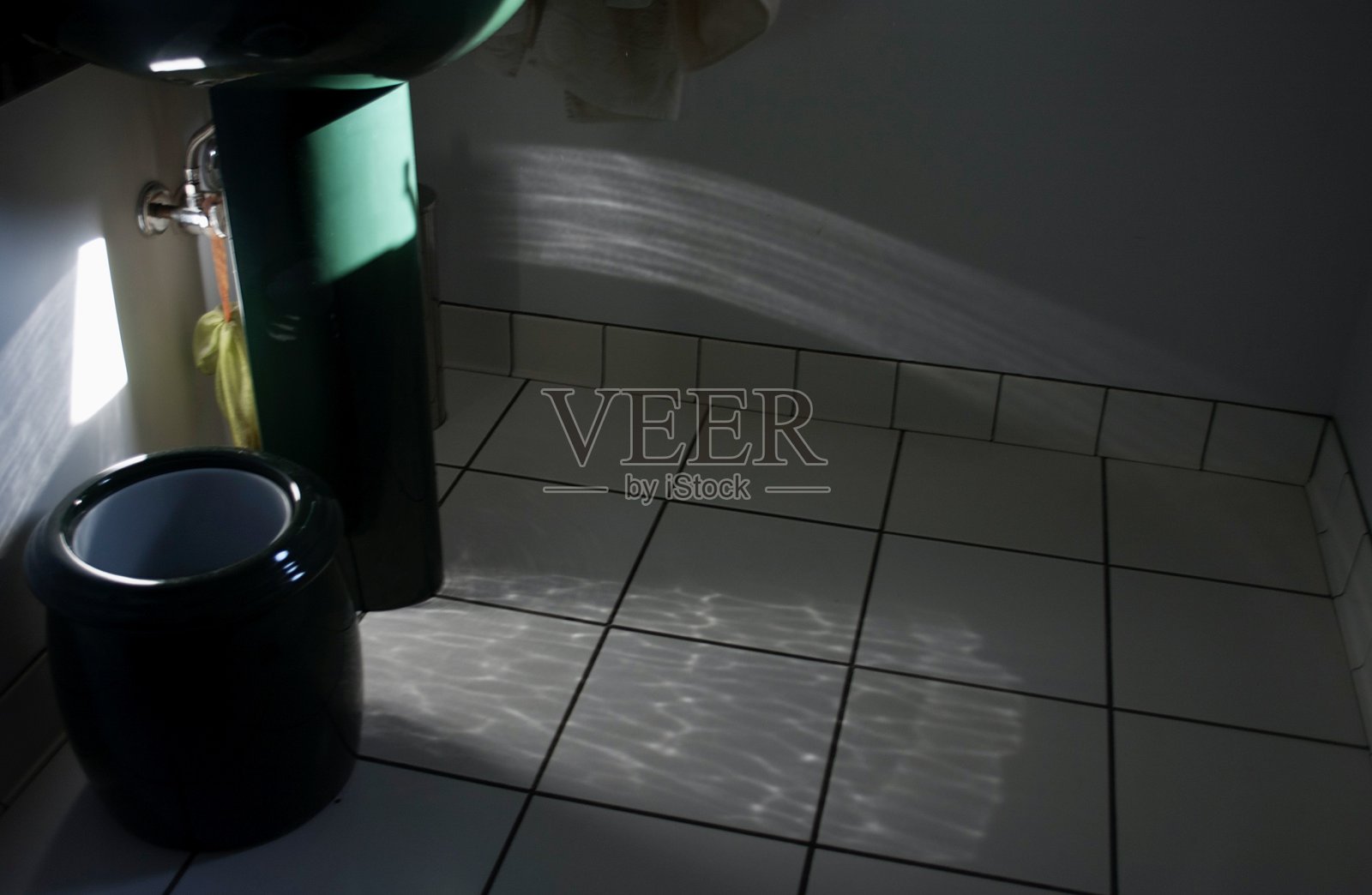 阳光照射在洗手池的碗上，反射到浴室的瓷砖上照片摄影图片