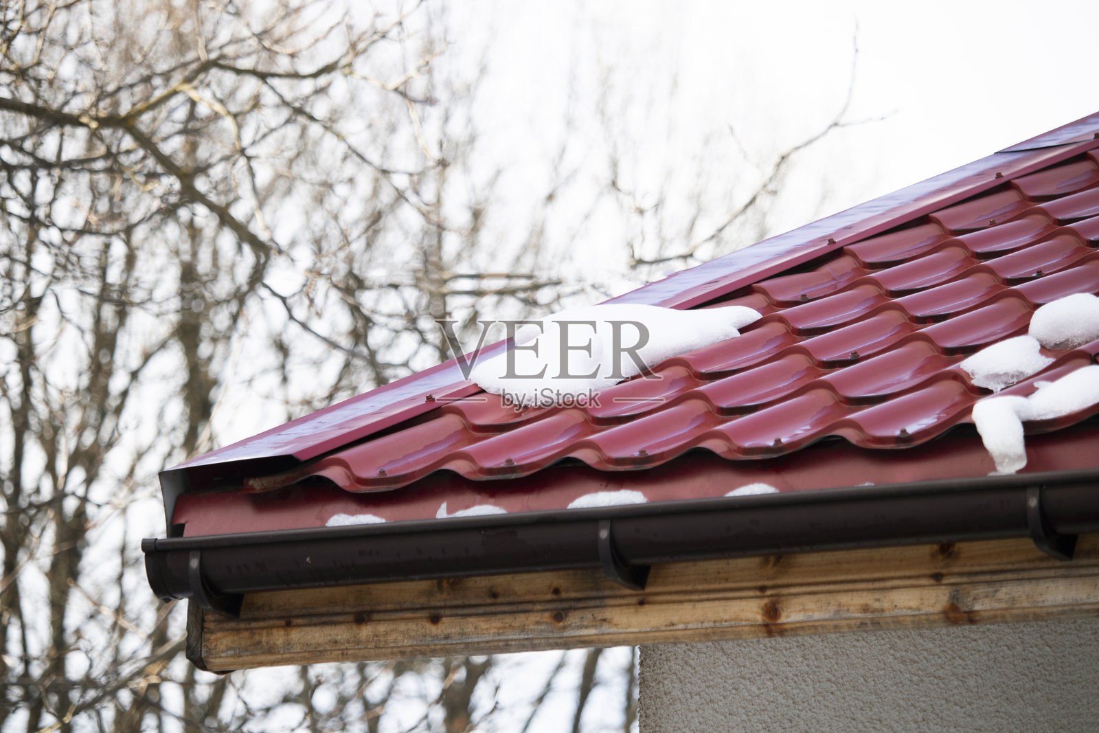 红色屋顶上融化的雪 - 特写照片摄影图片