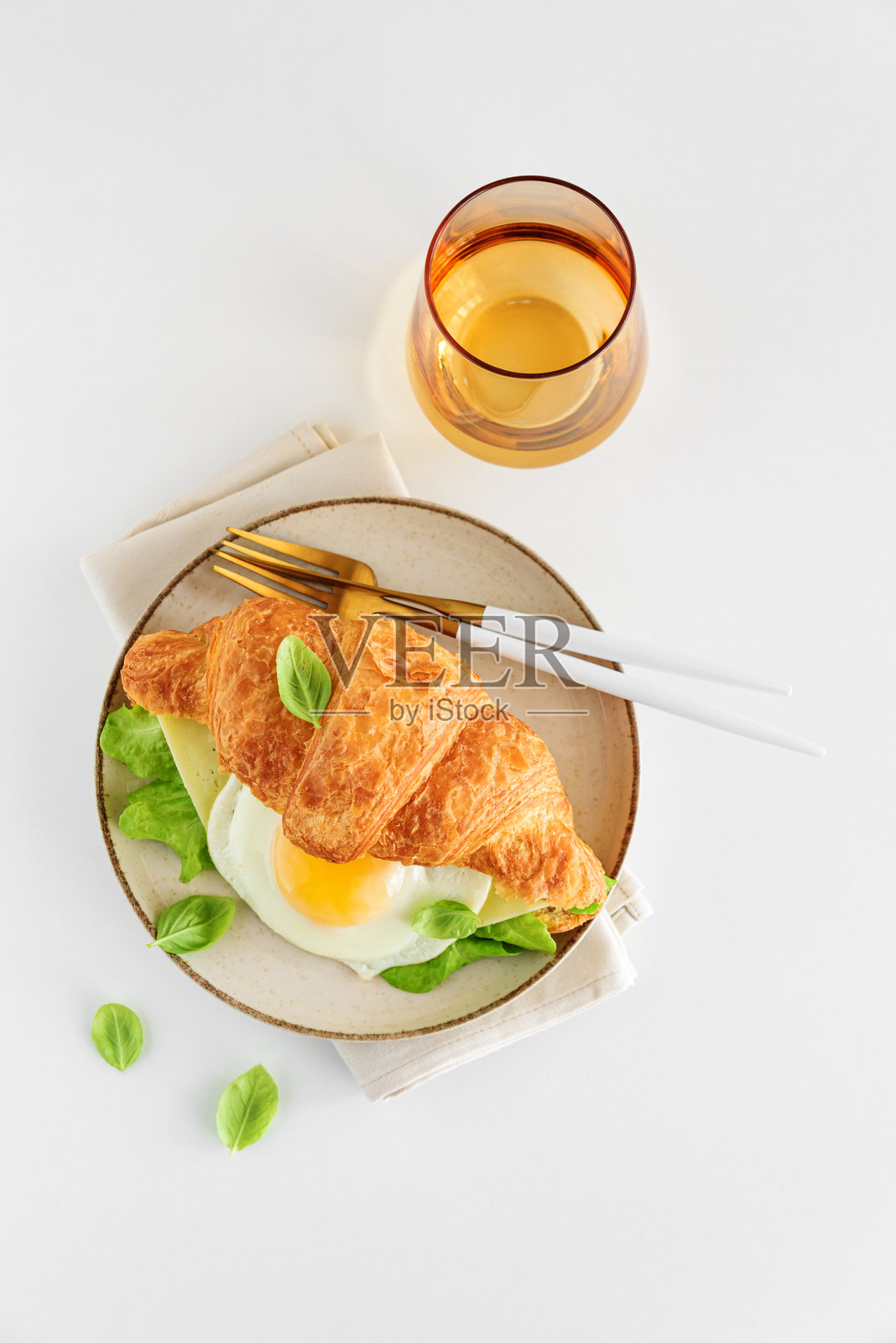 白色桌子上的可颂吐司，配有生菜、奶酪和煎蛋。俯视图照片摄影图片