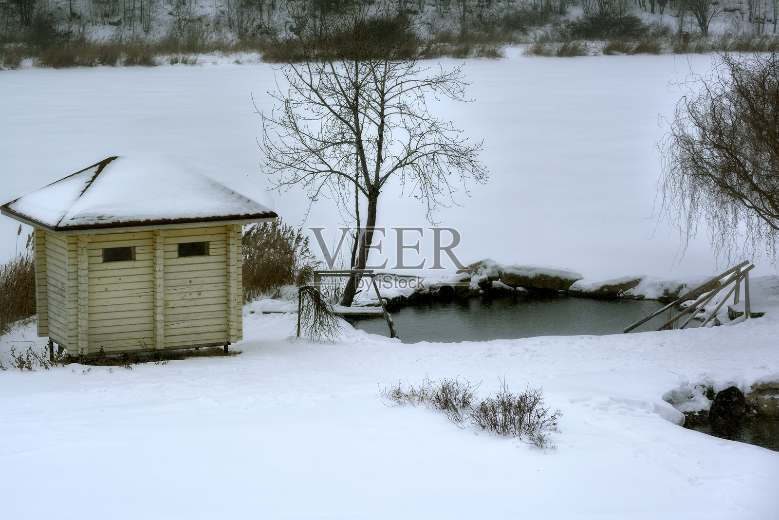 冬季游泳的字体，带有通往水中的栏杆和梯子。照片摄影图片