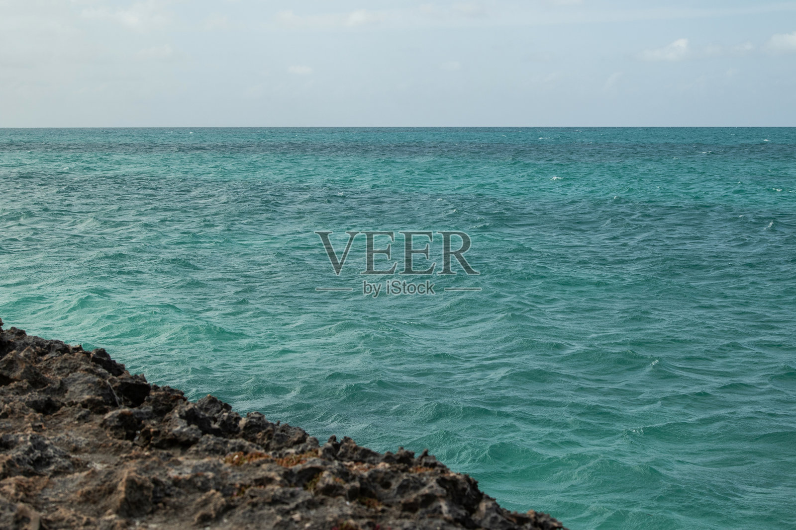 锯齿状的海岸岩石与碧蓝的海洋照片摄影图片