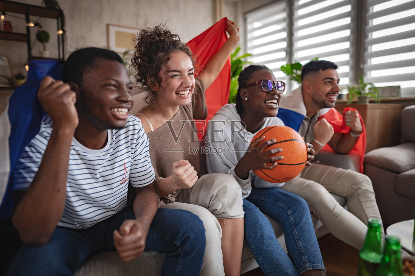 朋友们在看电视篮球比赛时为法国加油欢呼照片摄影图片