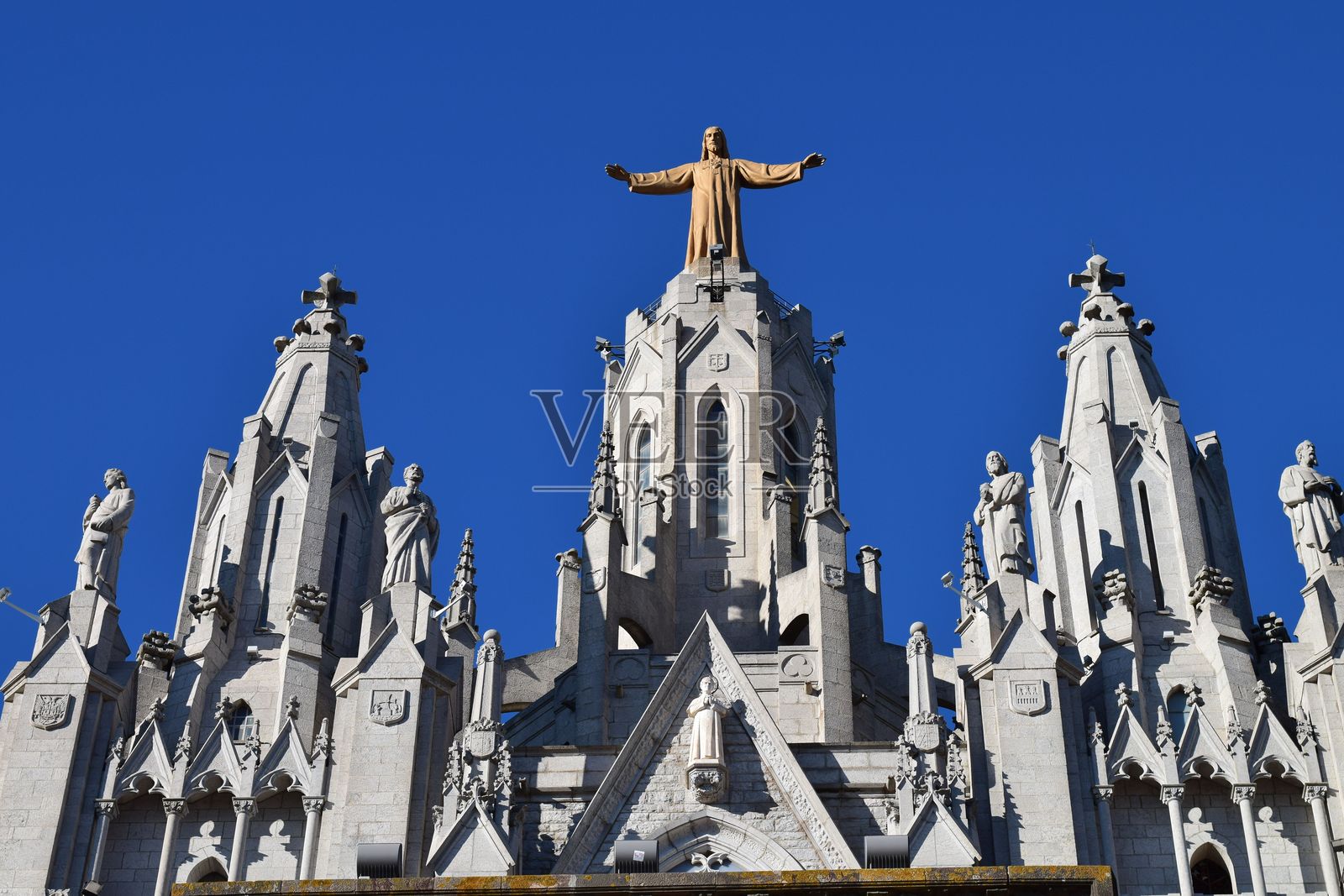 大教堂的顶部，上面有雕像，下面有耶稣的雕像照片摄影图片