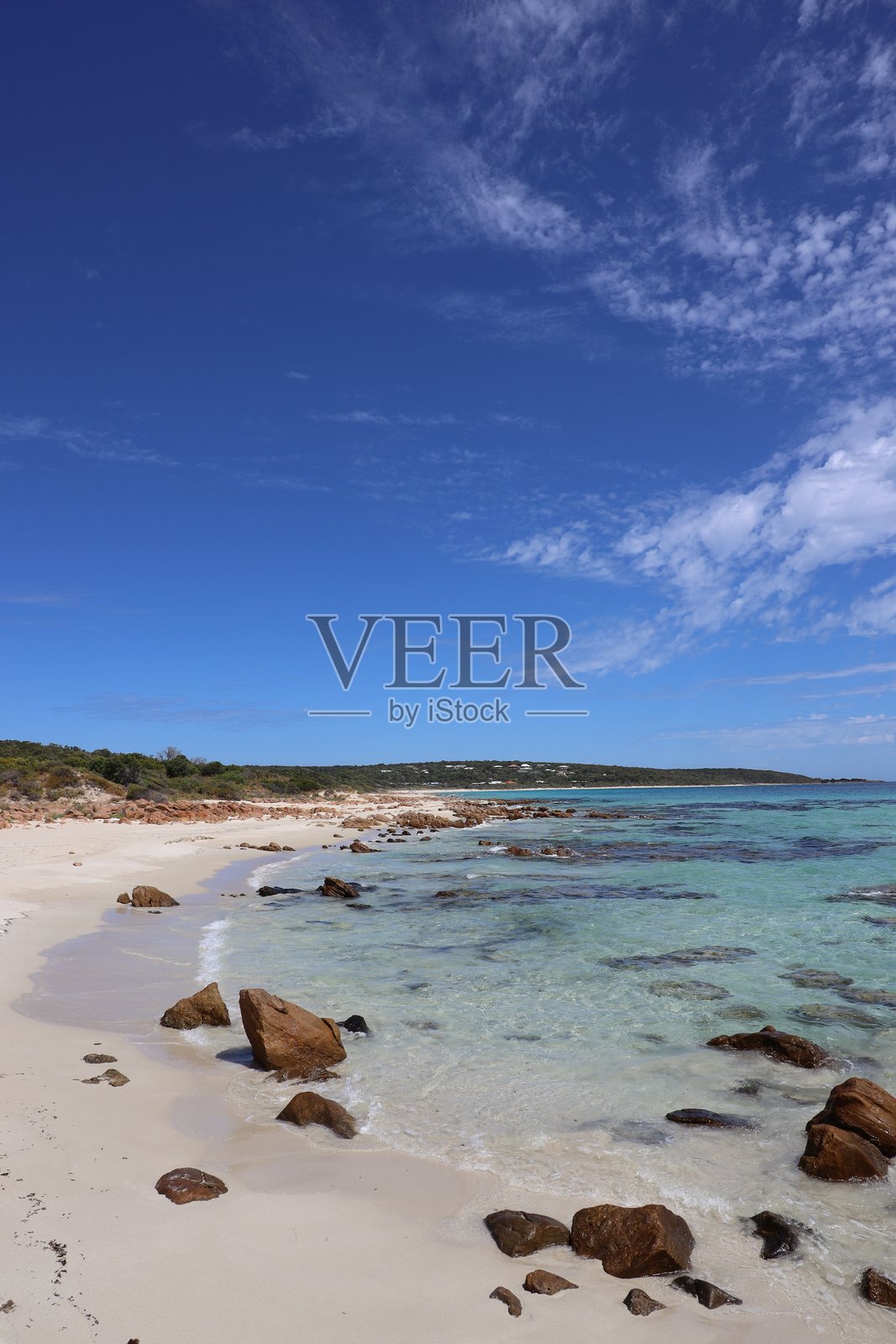 景观与空旷的海滩与岩石在清澈的水和原始的白色沙滩照片摄影图片