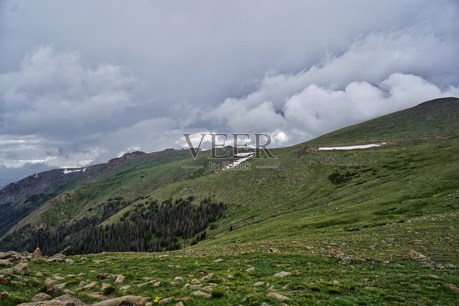 田园诗般的高山景观由郁郁葱葱的绿草，岩石地形和高耸的山脉组成照片摄影图片