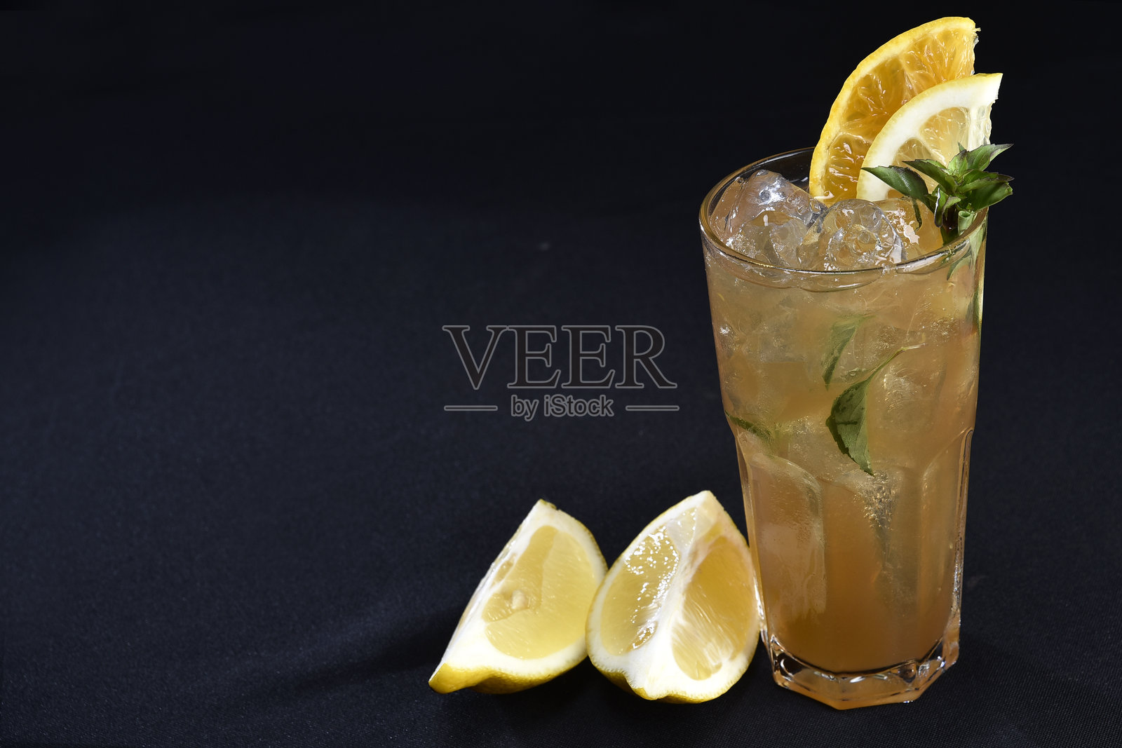 清爽的酒精饮料，有浆果、冰伏特加和杜松子酒，柠檬皮装在玻璃杯里，放在柜台上，背景模糊照片摄影图片