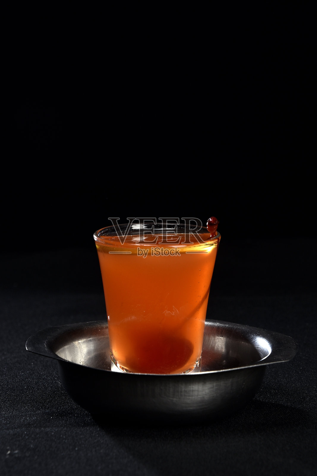 清爽的酒精饮料，有浆果、冰伏特加和杜松子酒，柠檬皮装在玻璃杯里，放在柜台上，背景模糊照片摄影图片