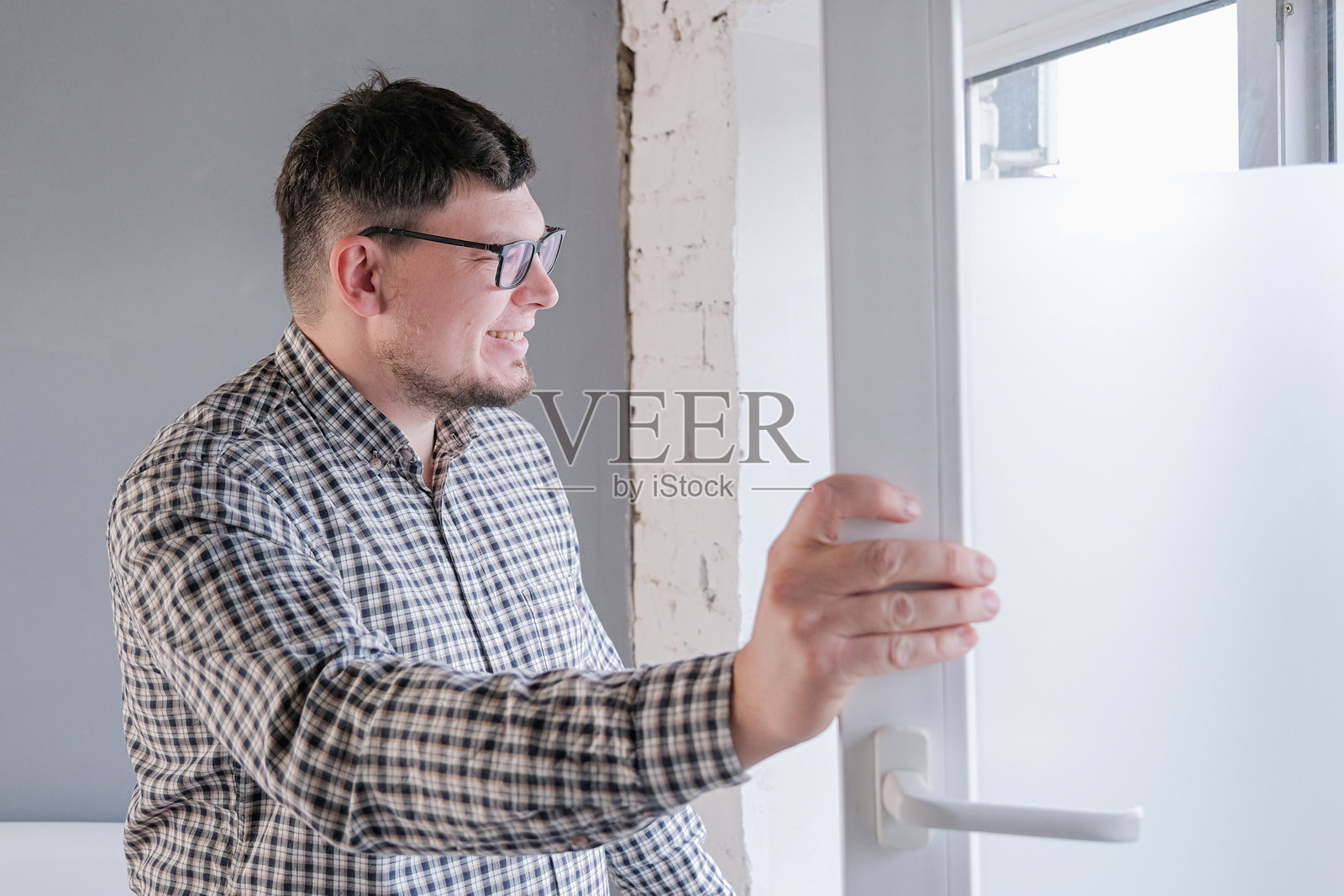 男人在家里清洁窗户。春季大扫除。照片摄影图片