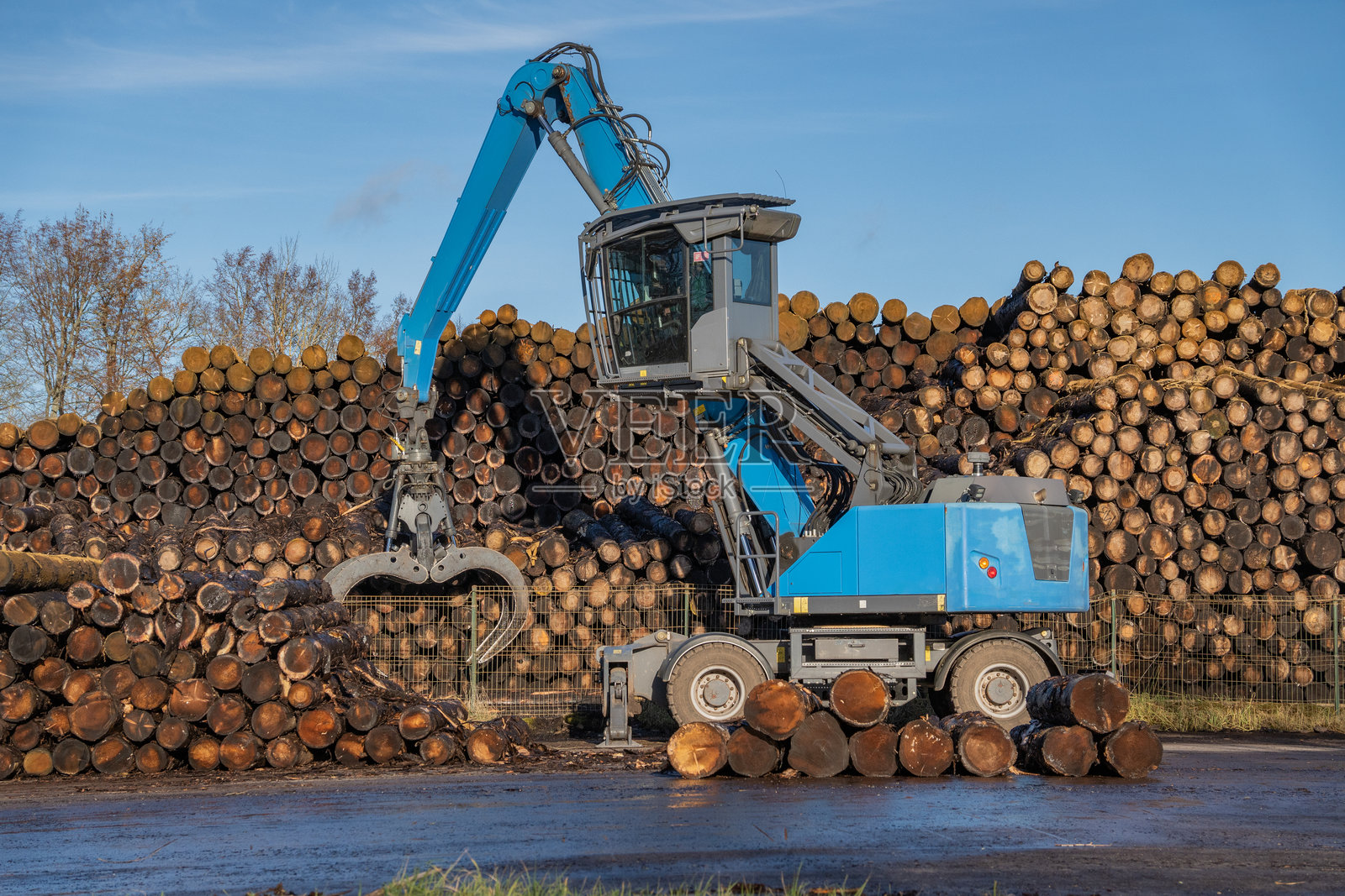 木材锯木厂，木材加工机械。加工厂。一名工人在操作装载机，现代木材加工厂，装载切割好的木材。照片摄影图片