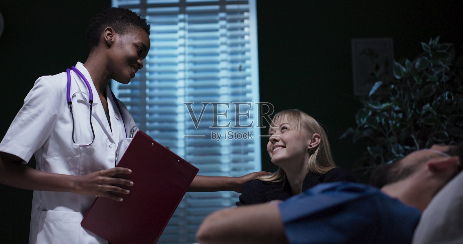 女人在医院病房里与生病的丈夫交谈。照片摄影图片