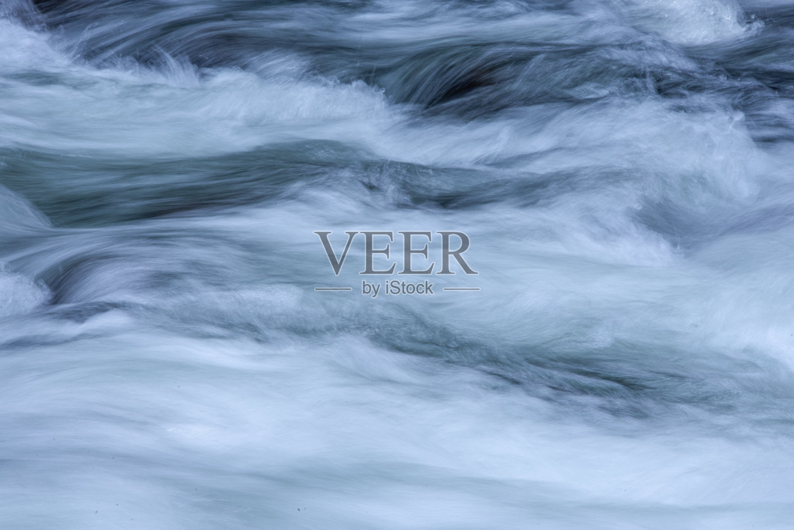 一张长时间曝光的照片，模糊了流动河流的运动。照片摄影图片