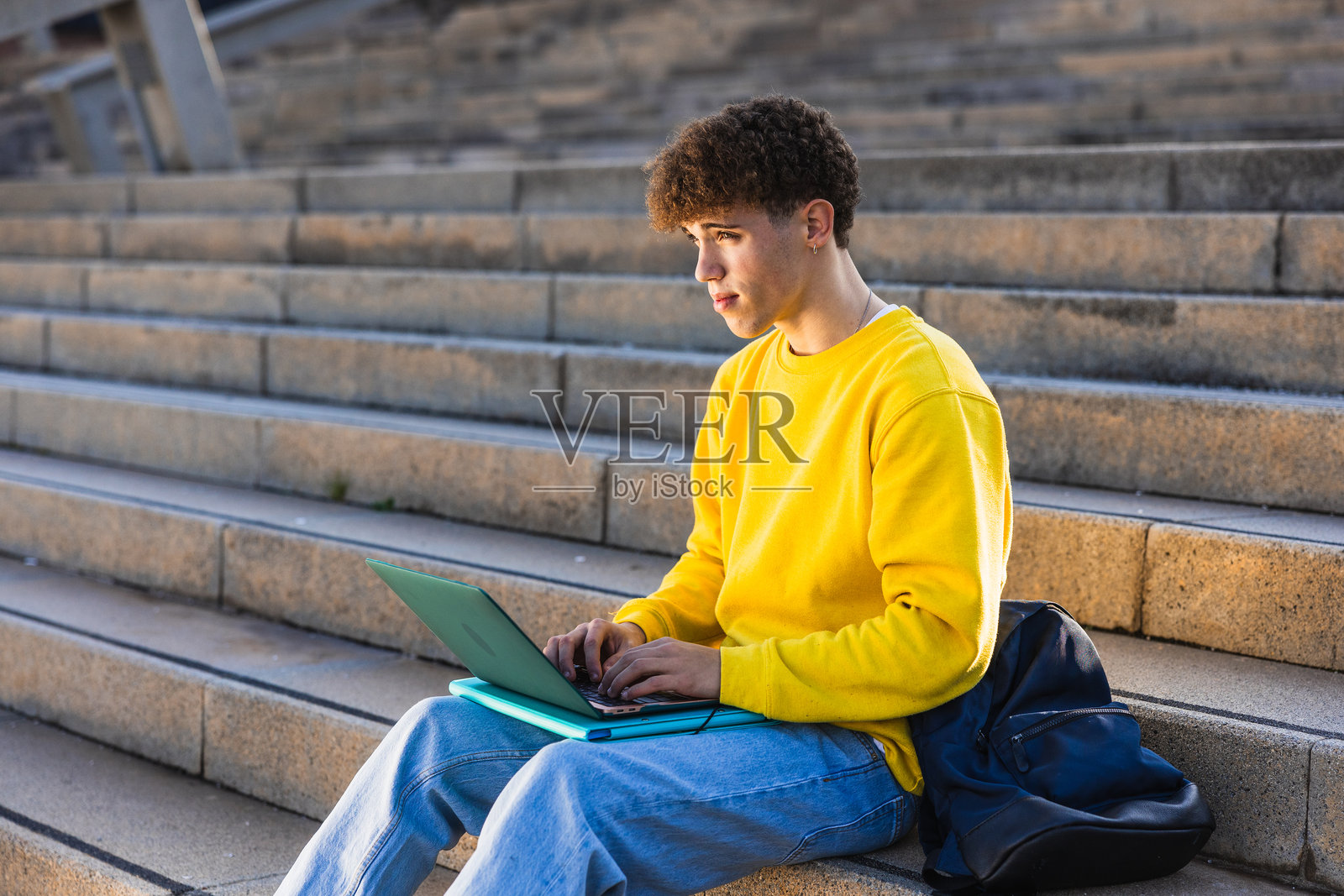 年轻大学生在户外台阶上用笔记本电脑学习照片摄影图片