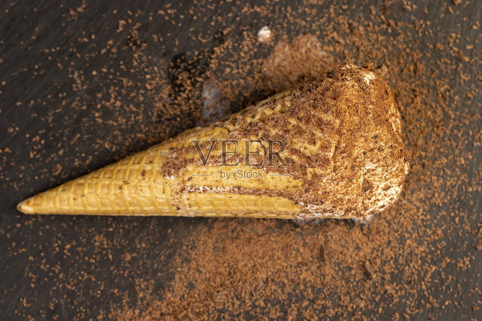 甜美融化的白色冰淇淋，配有巧克力碎片，装在华夫筒中照片摄影图片