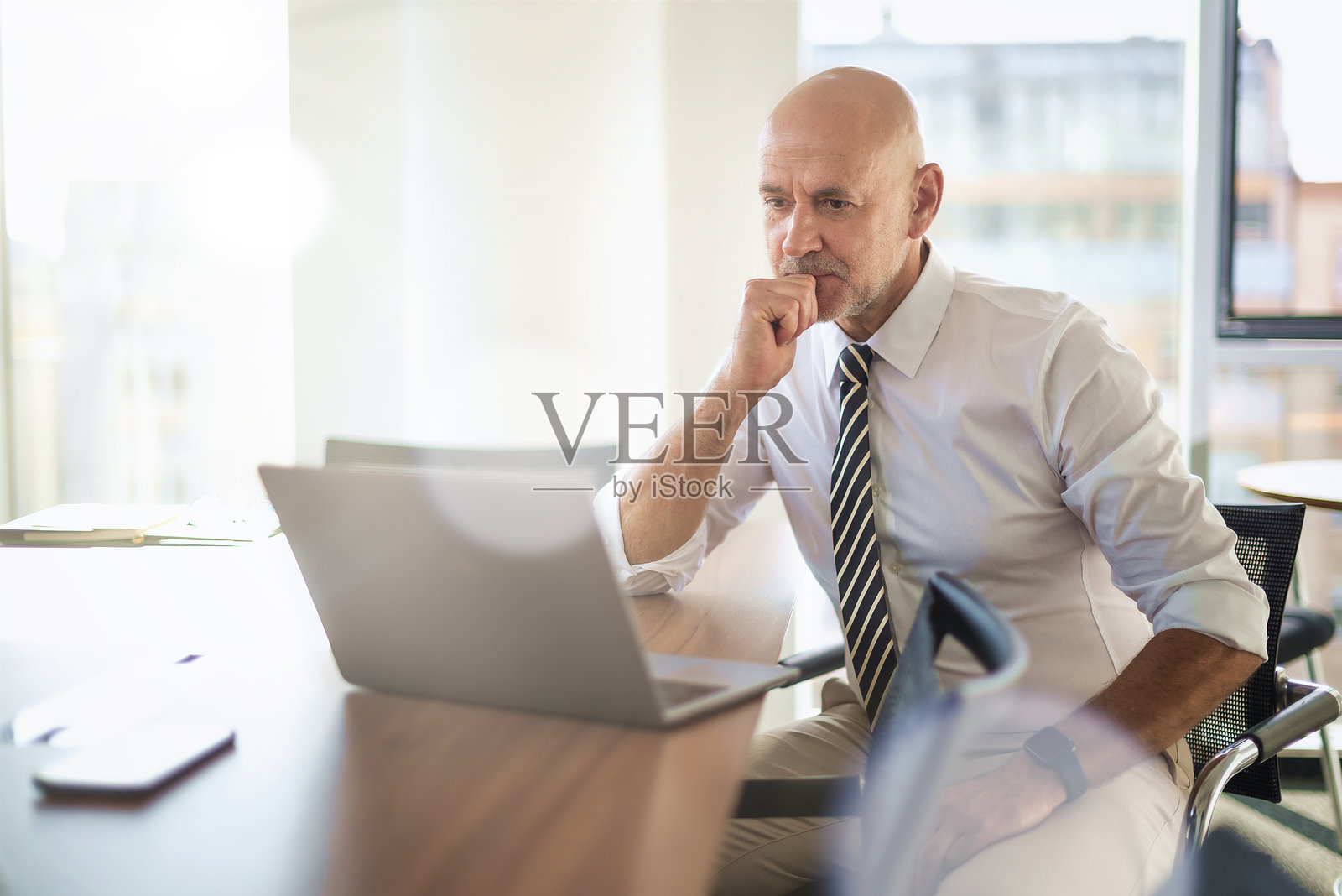 商人在现代办公室使用笔记本电脑照片摄影图片