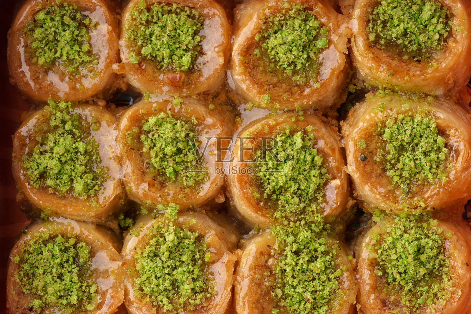 美味的甜点层次，包含开心果和蜂蜜，传统甜品在节日氛围中呈现。照片摄影图片